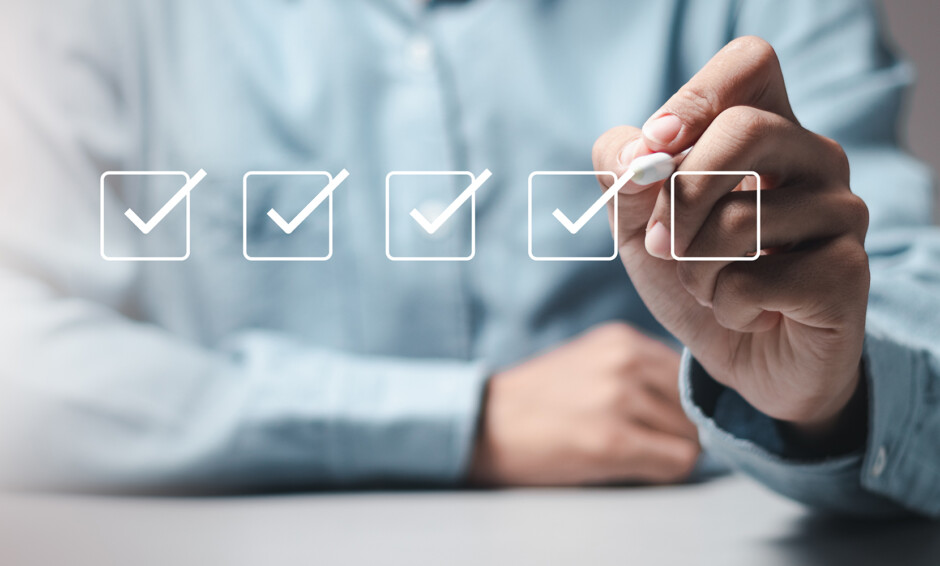 Person checking off items on a digital checklist, symbolizing organization and planning for winter office cleaning